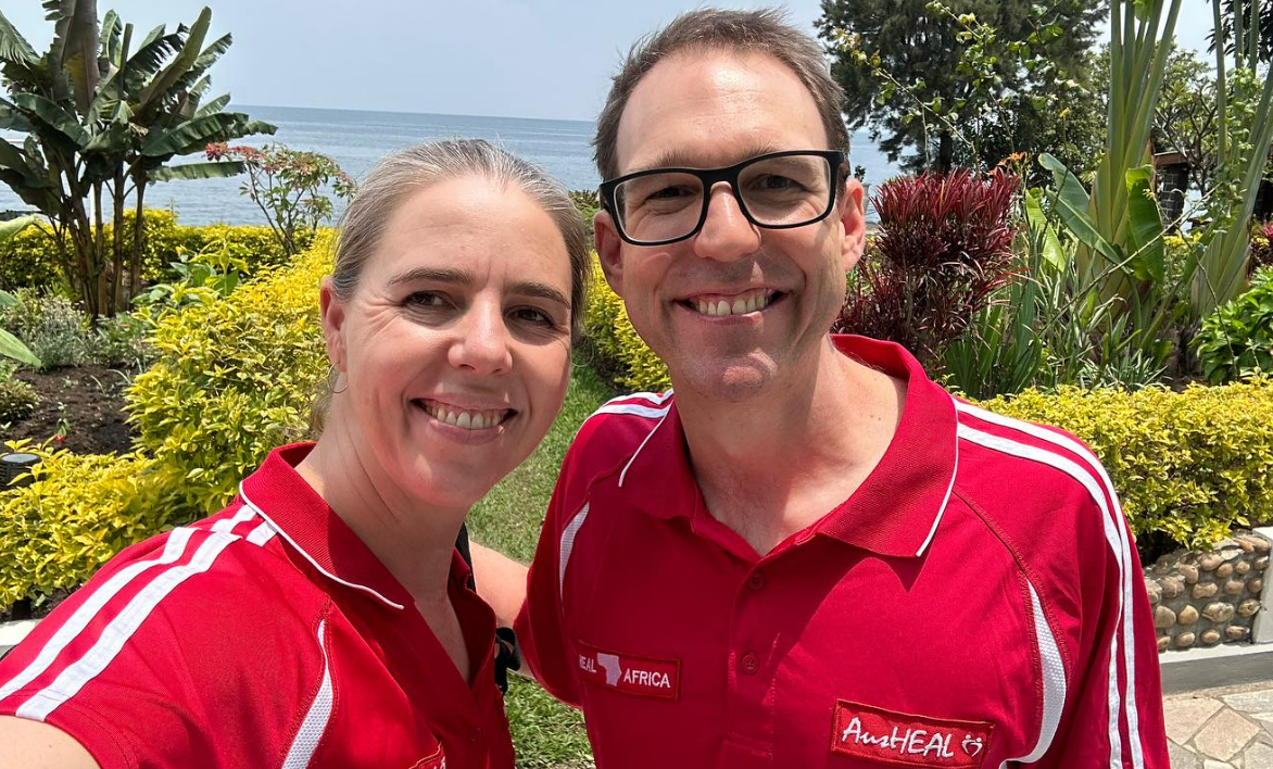 Doctors Heywood in red polo shirts standing in front of a tropical garden